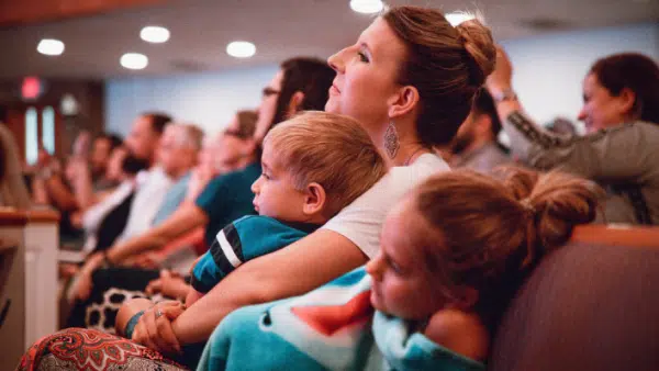 Mom sitting in church with kids in lap