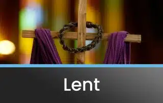 The cross with a crown of thorns and a purple drape, set up for lent services.